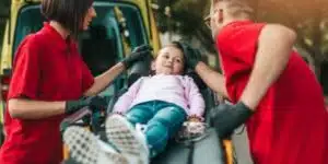 due operatori sanitari che trasportano su una barella una bambina 