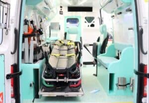 interno di un'ambulanza con barella, attrezzatura specifica e sedute per accompagnatori e personale sanitario 