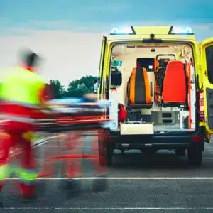 operatore che va verso l'ambulanza con una barella