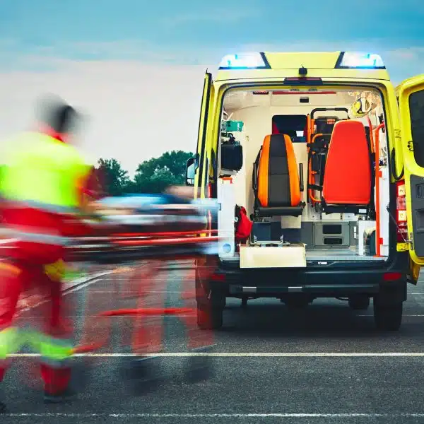 operatore che va verso l'ambulanza con una barella