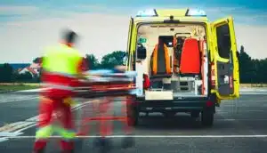 operatore che porta un paziente su barella dentro a un'ambulanza 