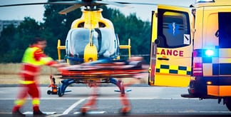 operatore sanitario che trasferisce un paziente da un'ambulanza a un eliambulanza 